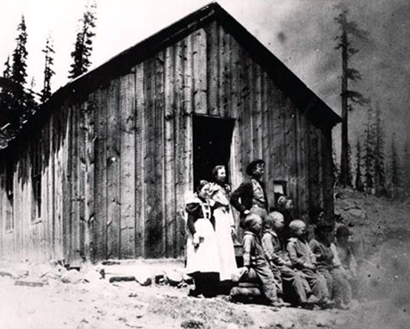 Photograph taken in front of Leavick’s schoolhouse. From left to right, standing: Lucille Rudd, Alice McLaughlin (teacher), Williams children and seated Rossman’s children.