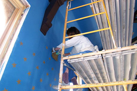 Leadville local Lisa Dowdney and her sister, Deborah Seaman (not pictured), painting the stars on the walls and the ceiling using the stencils with gold metallic paint. The stars on the walls are the same size and laid out in a pattern. The stars on the ceilings are several sizes and randomly laid out.
